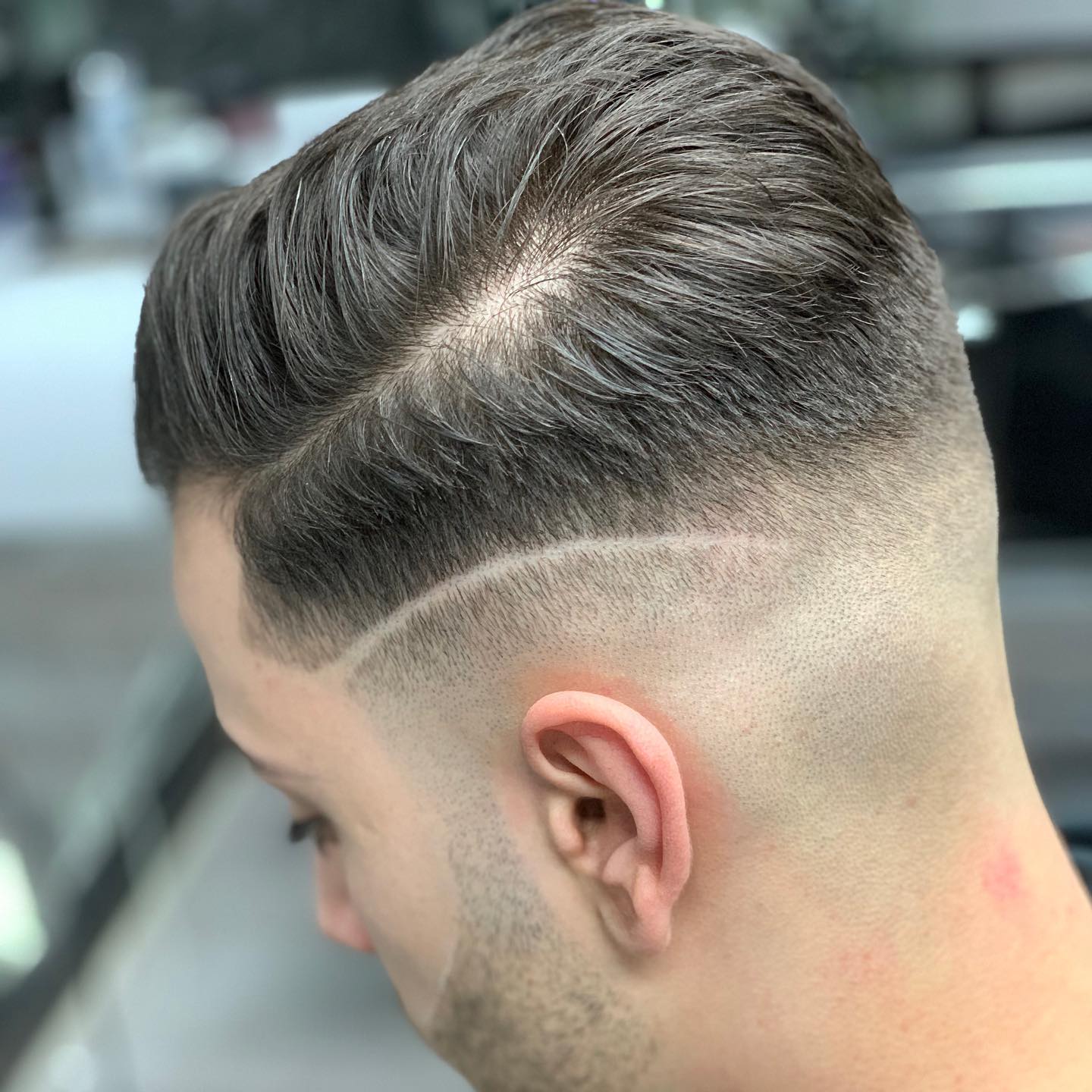 Skin fade met hard part en side part